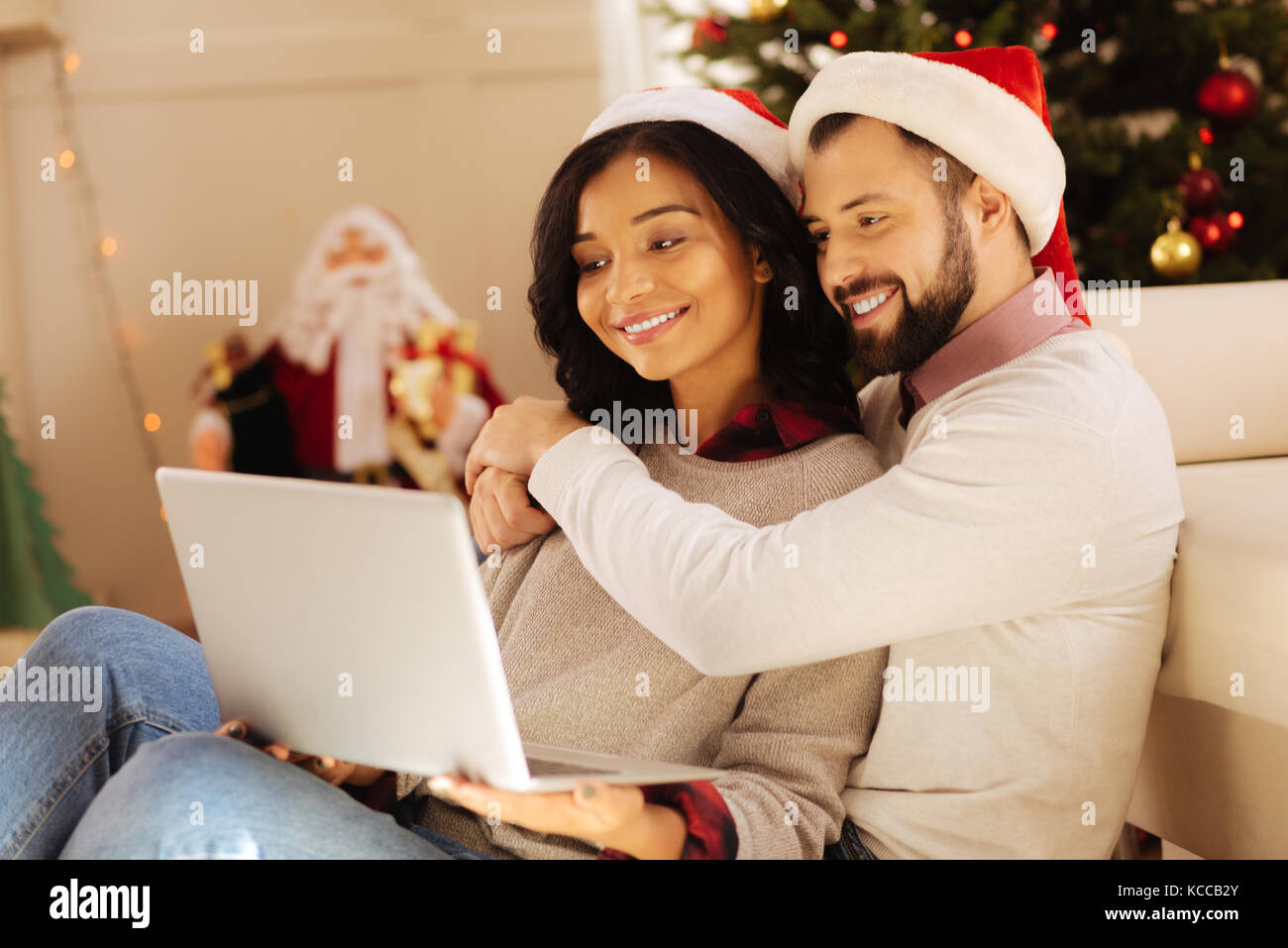 Happy couple cuddling while watching film on laptop Stock Photo Alamy