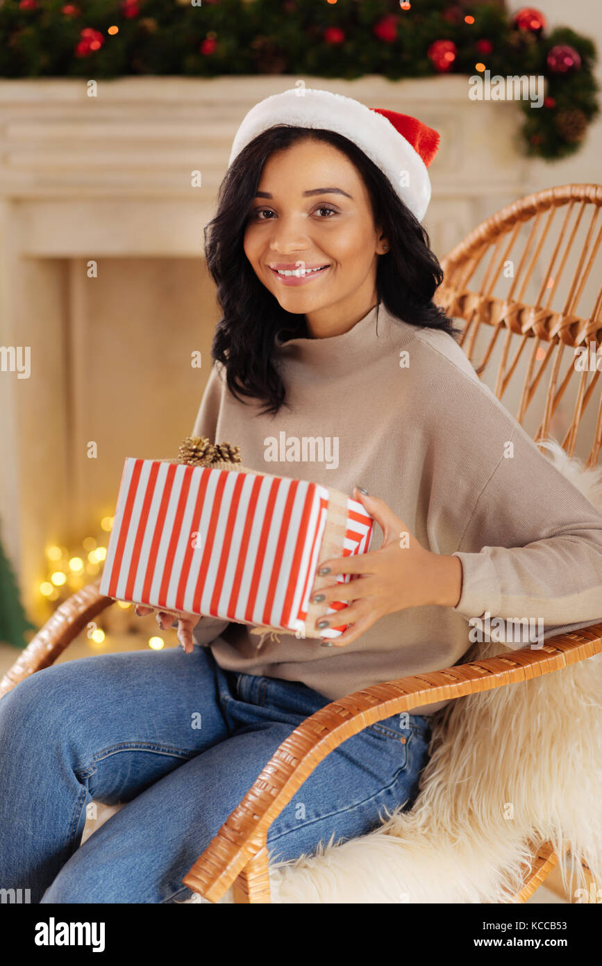Charming woman posing in rocking chair with Christmas gift Stock Photo ...