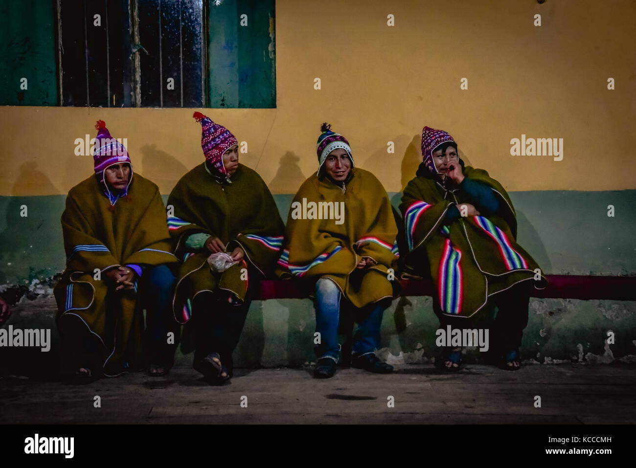 Peruvian men sat on bench in traditional dress Stock Photo
