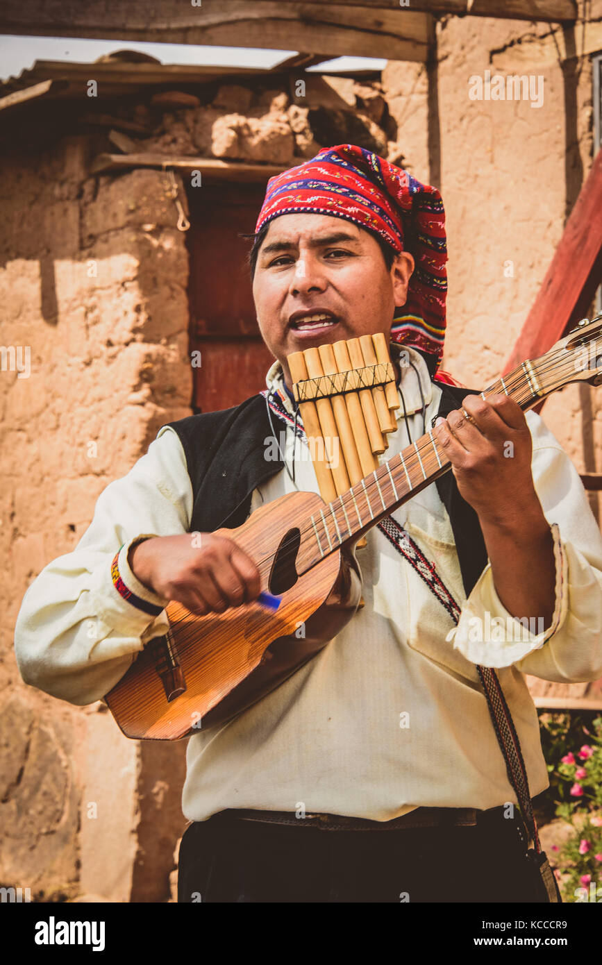 Peruvian man playing pipes & ukelele Stock Photo