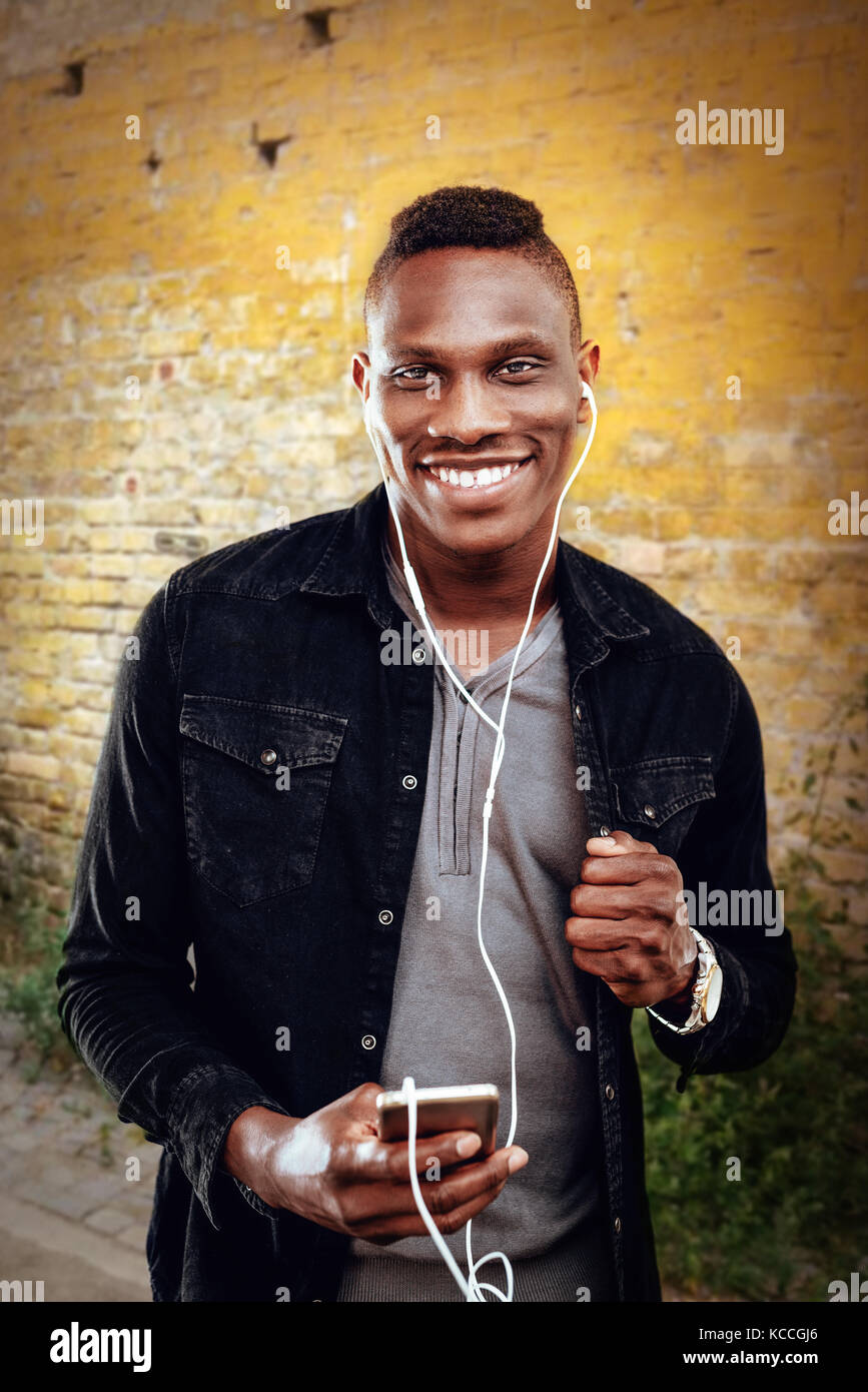 African guy wearing headphones and listening to music Stock Photo Alamy