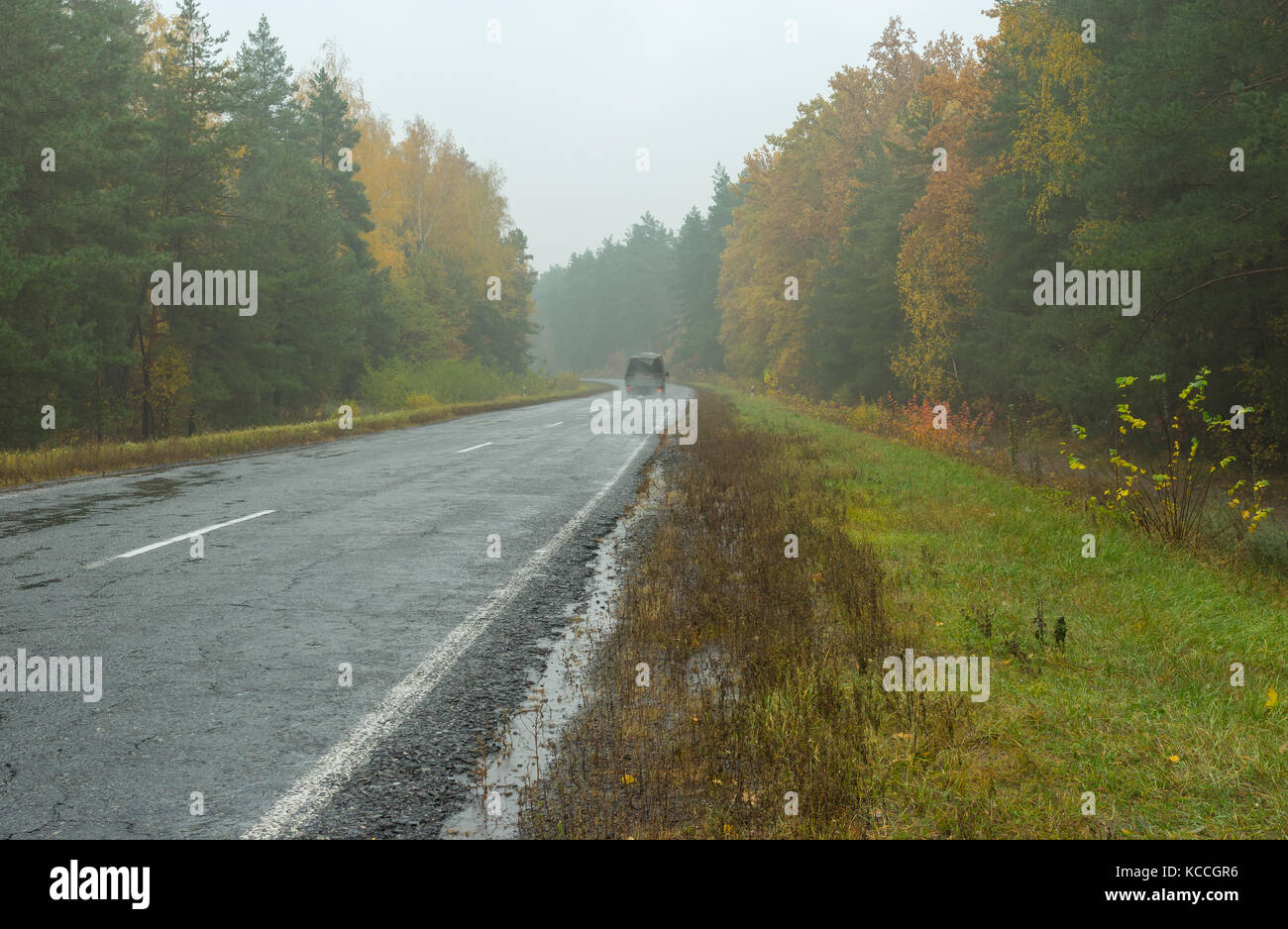 Autumnal landscape with highway, rainy weather and lonely motor transport Stock Photo