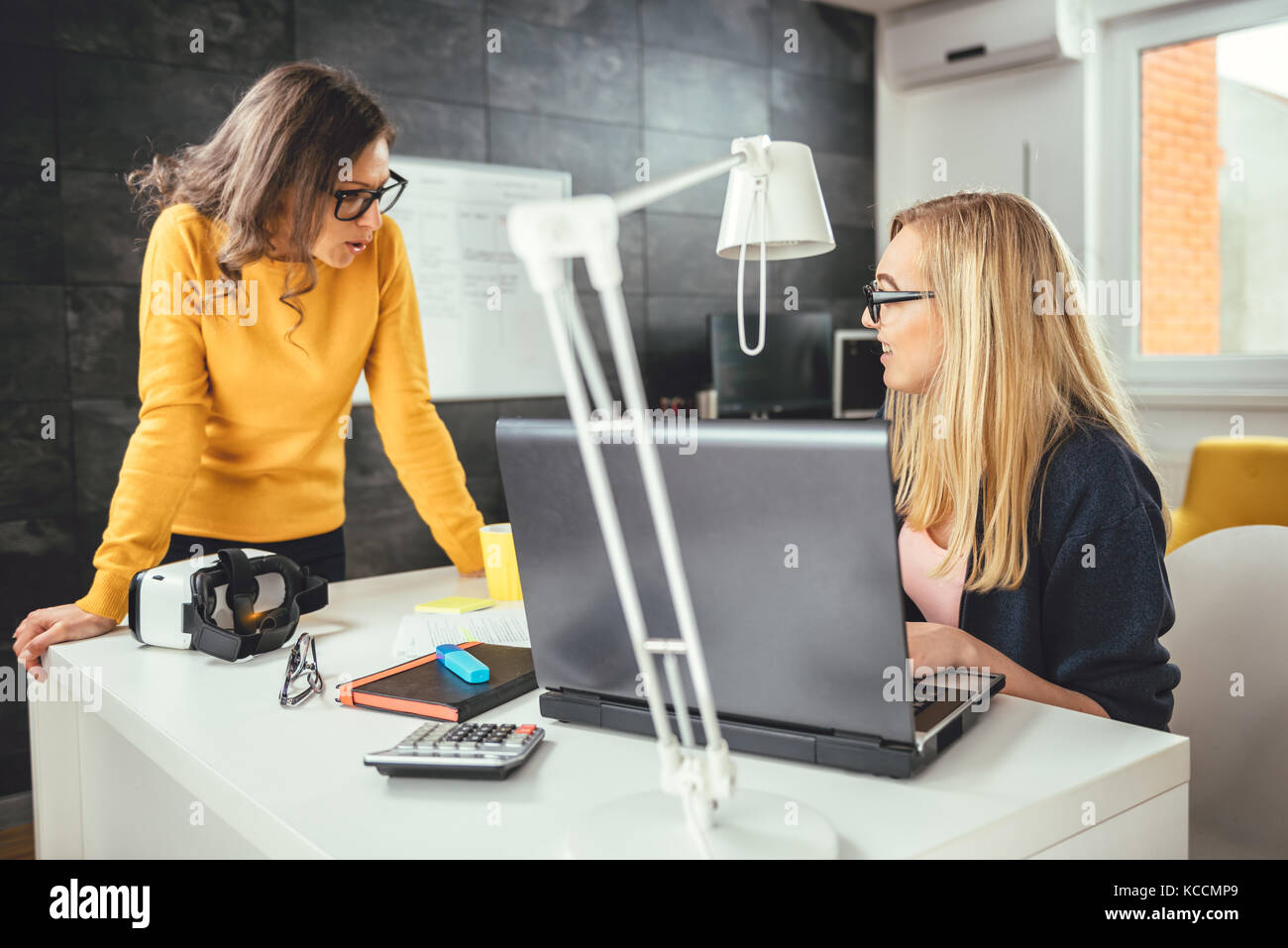 Two business woman working together at the office Stock Photo - Alamy