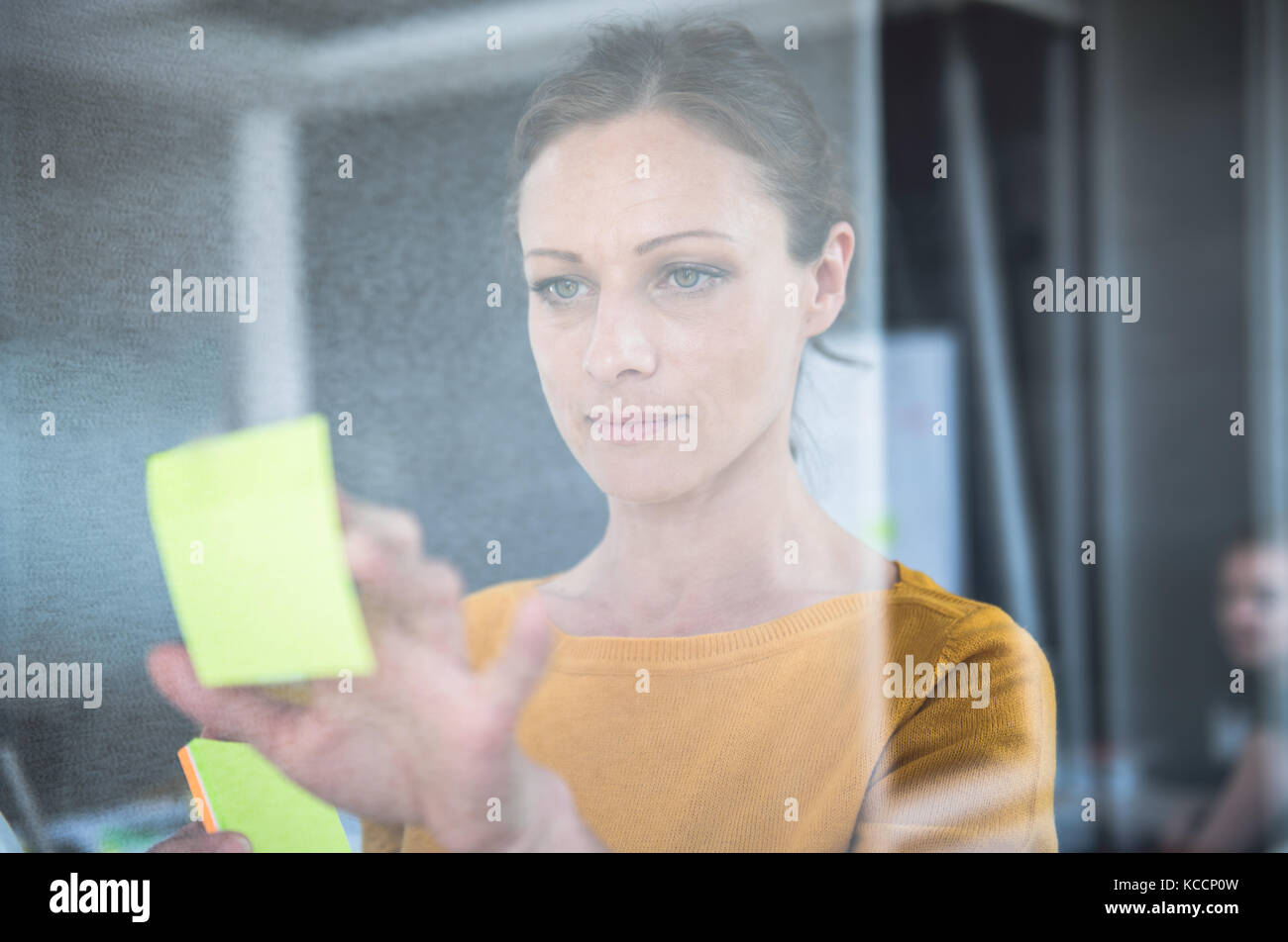 Woman writing notes on the glass board at the office Stock Photo Alamy