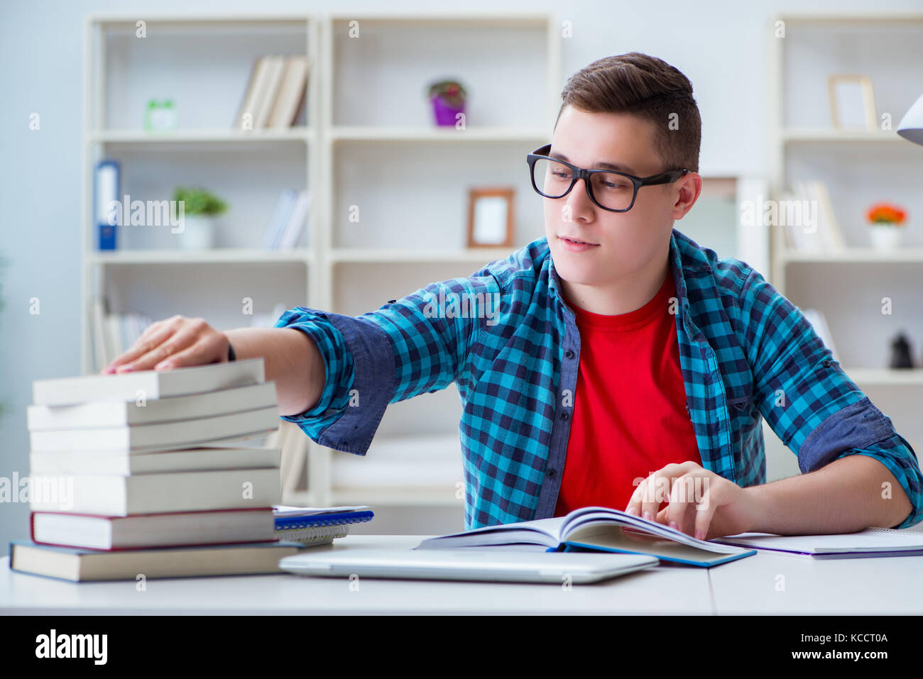 Student Preparing Young teenager preparing for exams studying at a desk indoors Stock ...
