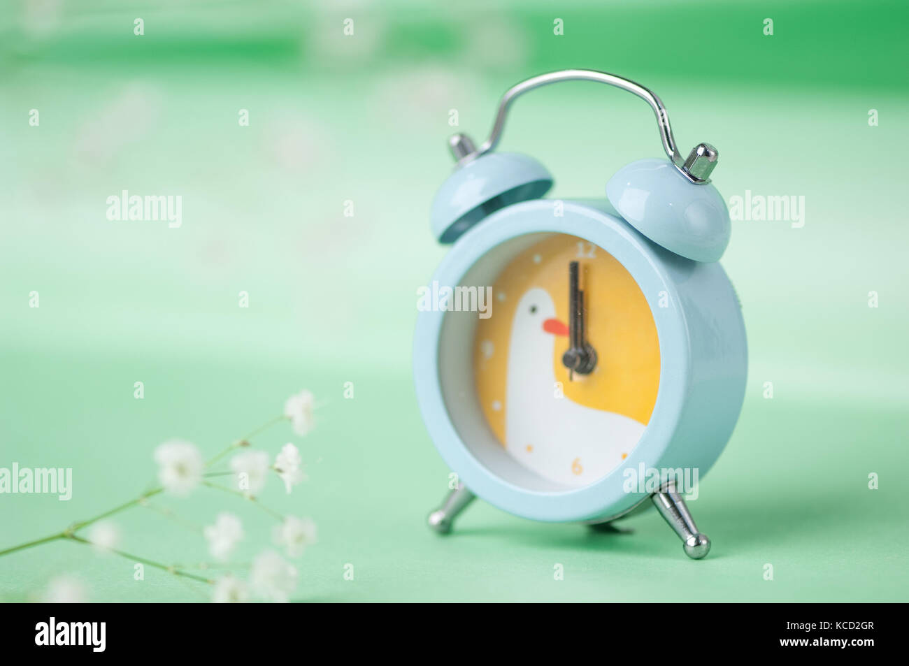 blue clock with a bird pattern on a green blurred background Stock ...