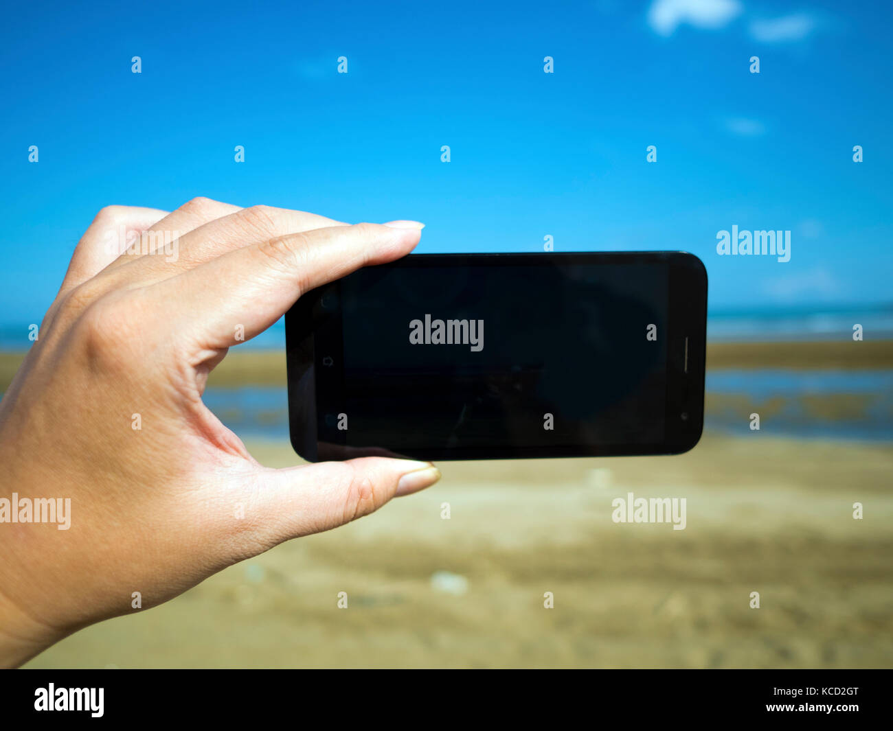 smart phone on hand at summer beach Stock Photo