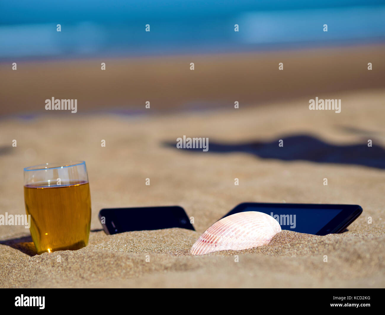 tea with smart phone and shell on summer beach Stock Photo