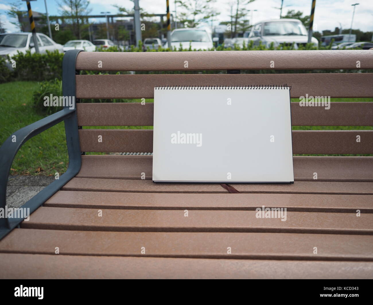 blank white note book on bench in park Stock Photo