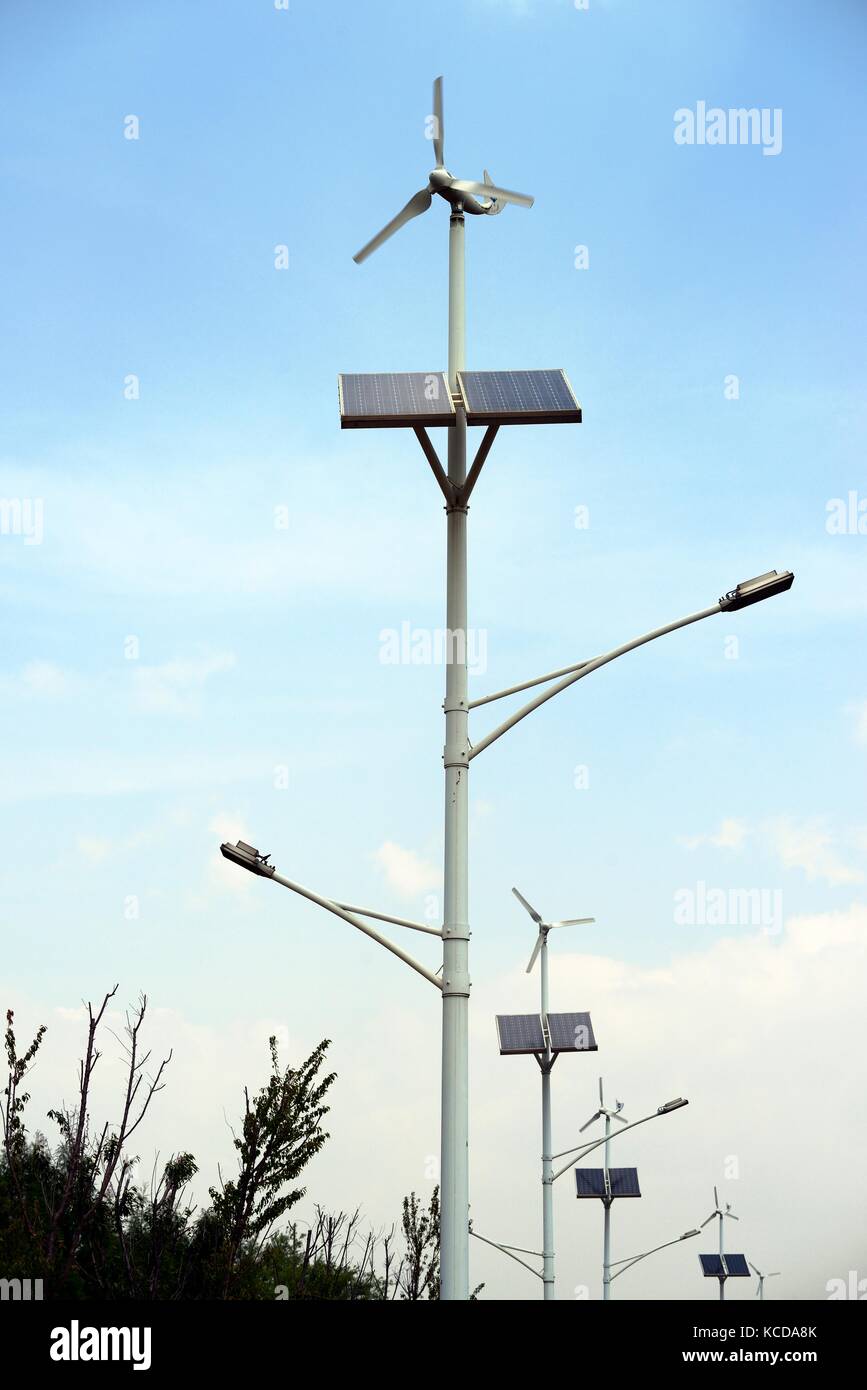 Standalone eco friendly solar panels and wind turbine generators integrated lamp posts street lighting on roadside highway. Kunming, Yunnan, China Stock Photo