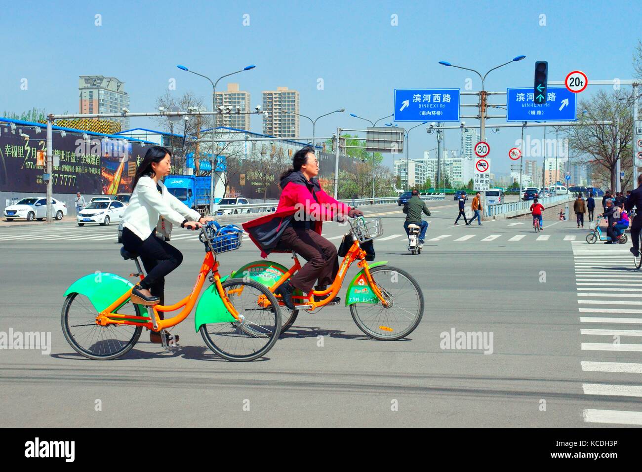 Cyclists China use public bicycle sharing bike share system bikes in Taiyuan city street Shanxi Province. Chinese transport traffic road intersection Stock Photo