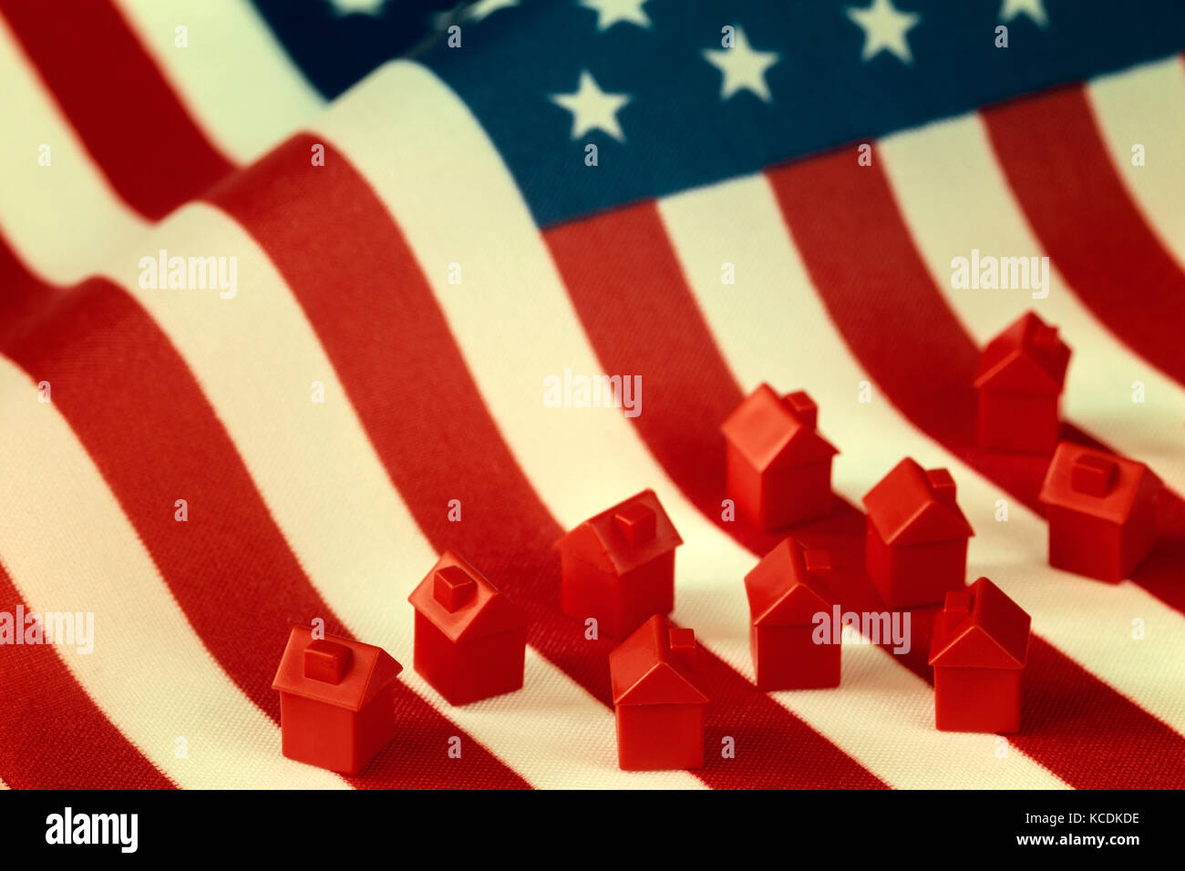 Mini houses against USA flag background. Citizenship, residence, property, real estate concept. Stock Photo