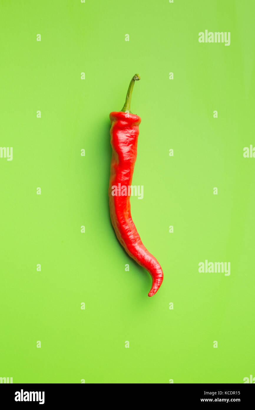 Red chili peppers on green background Stock Photo - Alamy
