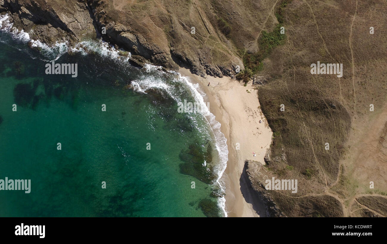 Aerial photo of a little sunny beach in a sea bay between rocks. Stock Photo