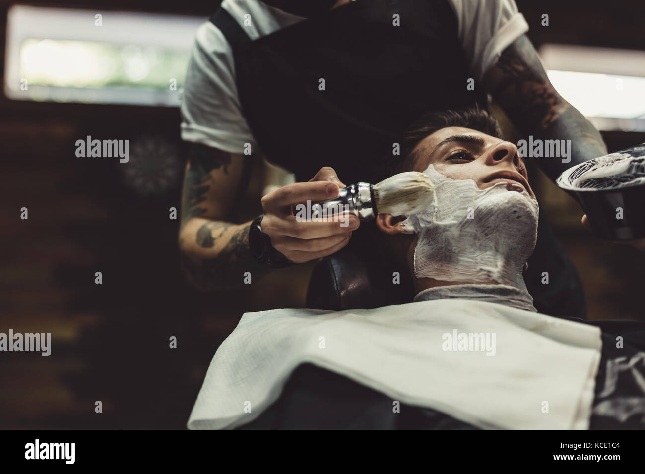 Barber shaving client Stock Photo