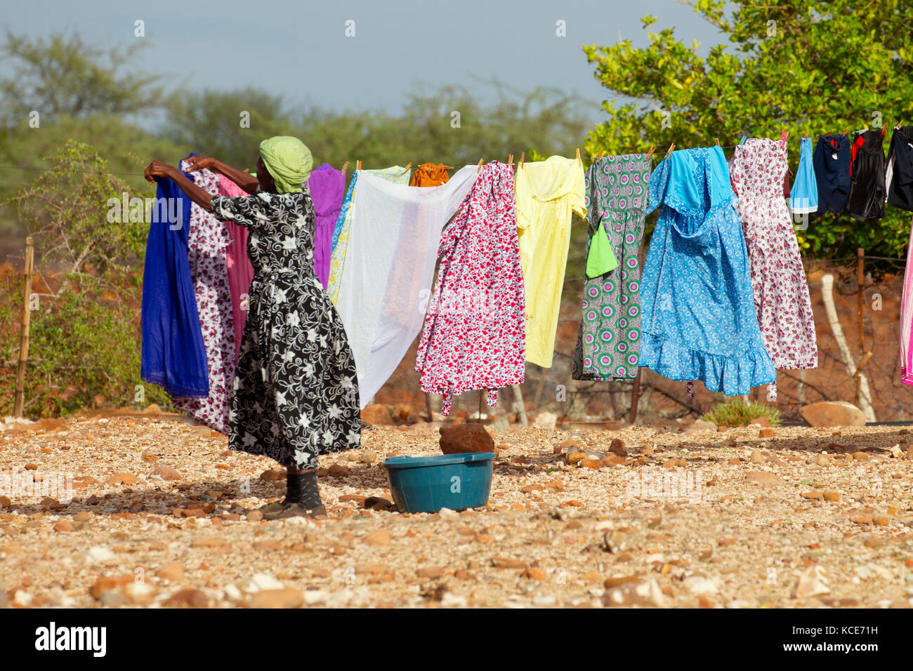 Elderly Village woman drying washing living in rural village Namibia Africa Stock Photo