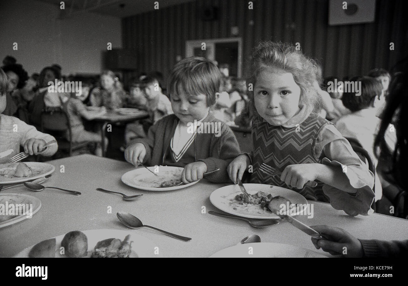 1970s, historical, two young girls eating their school dinner at Langbourne Primary School, Dulwich, London, England, UK. Stock Photo