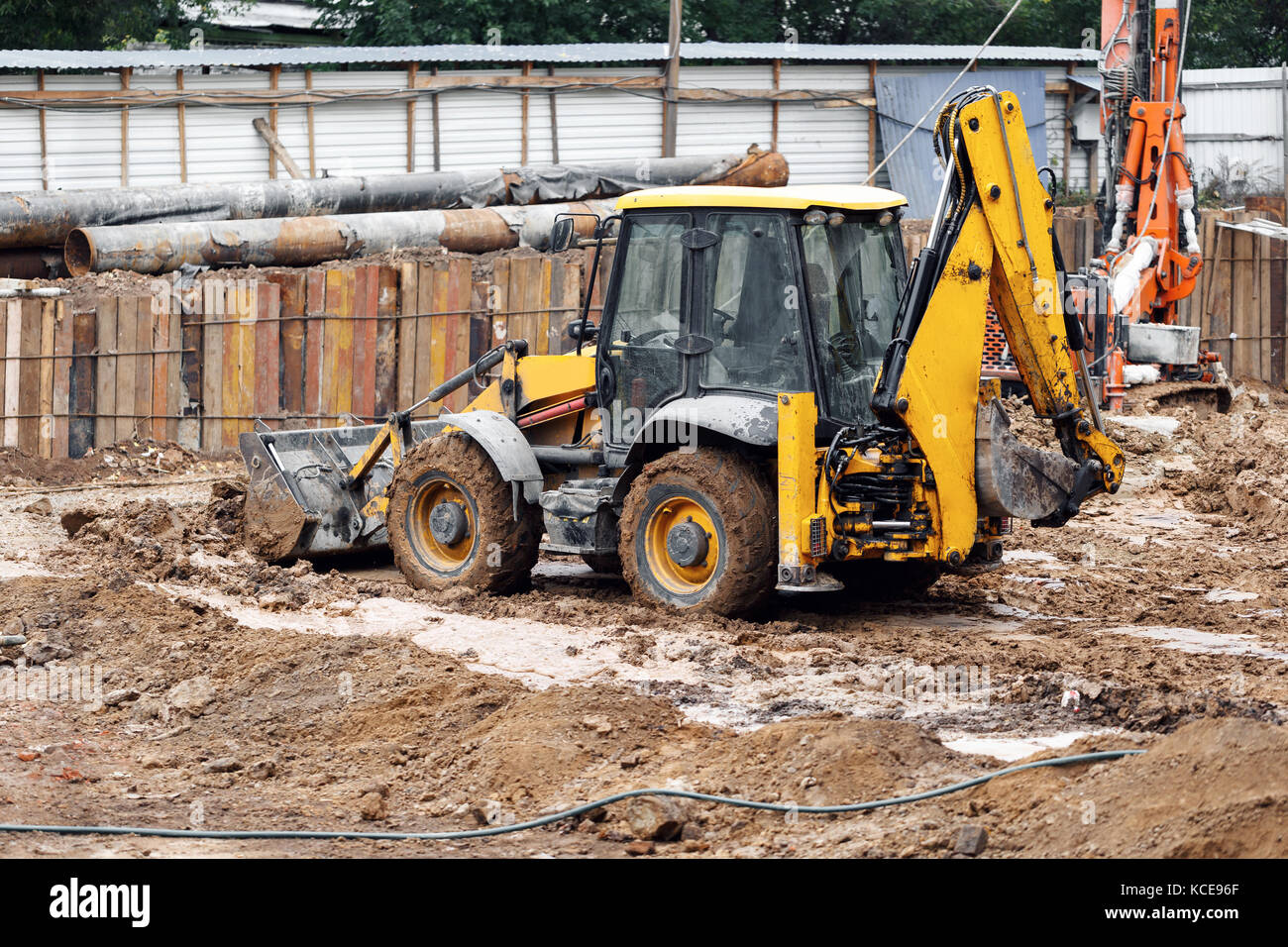 Tractor excavator with bucket rides running through mud lands setting