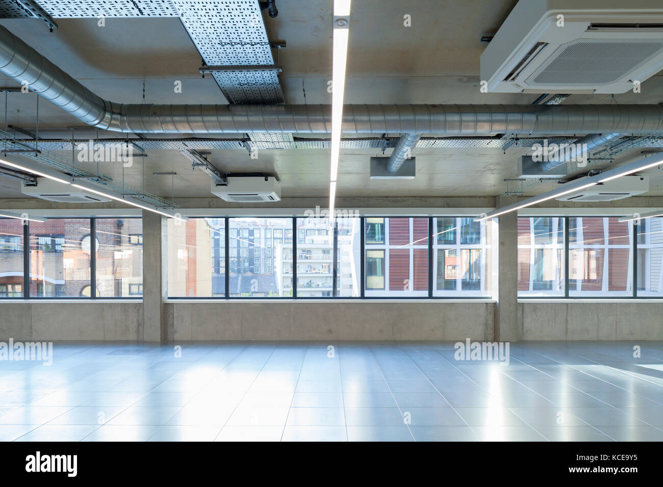 Empty commercial office space with visible services and air conditioning on the ceiling. Stock Photo