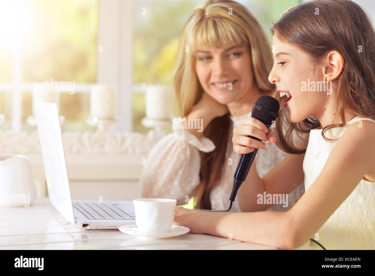 Portrait of a mother and daughter singing karaoke together Stock Photo