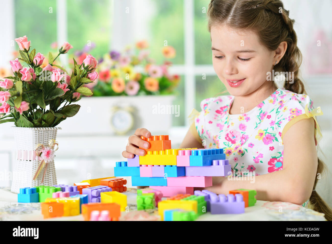 Adorable little girl playing with colorful plastic blocks Stock Photo ...