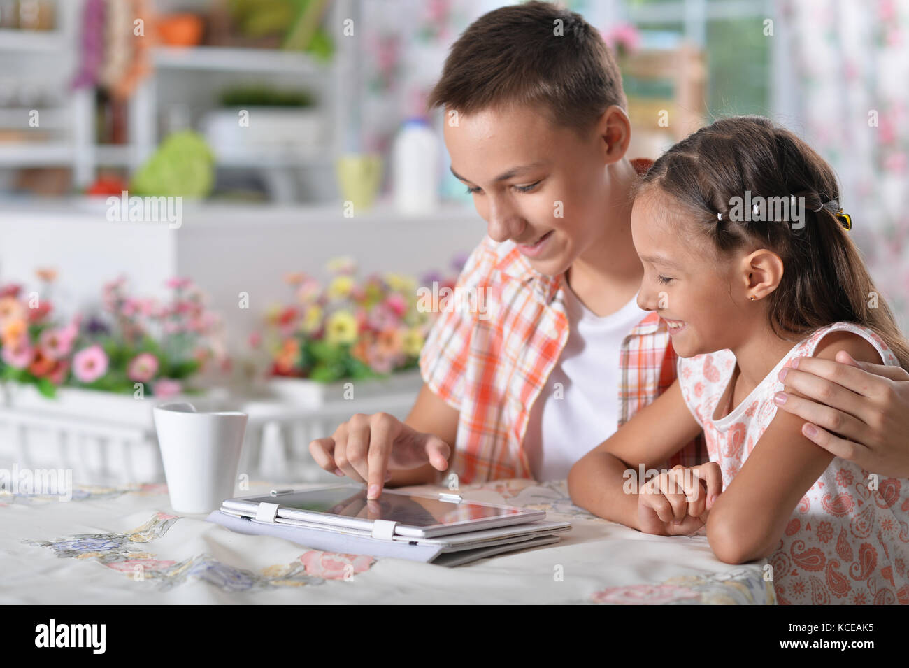 Brother and sister using tablet Stock Photo - Alamy