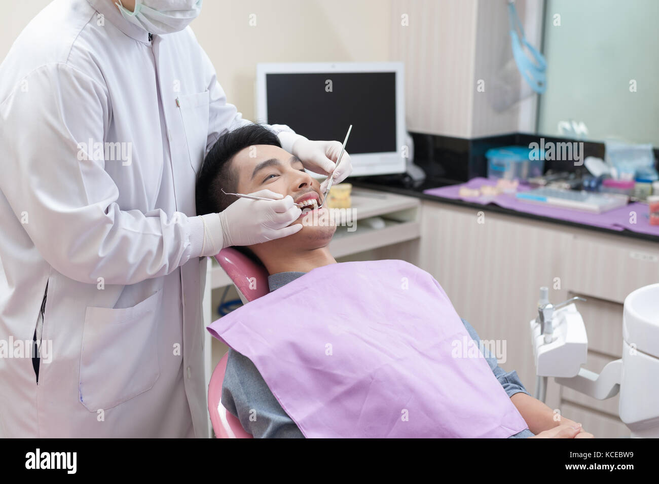 A man getting dental treatment in clinic with dentist. Dental care and
