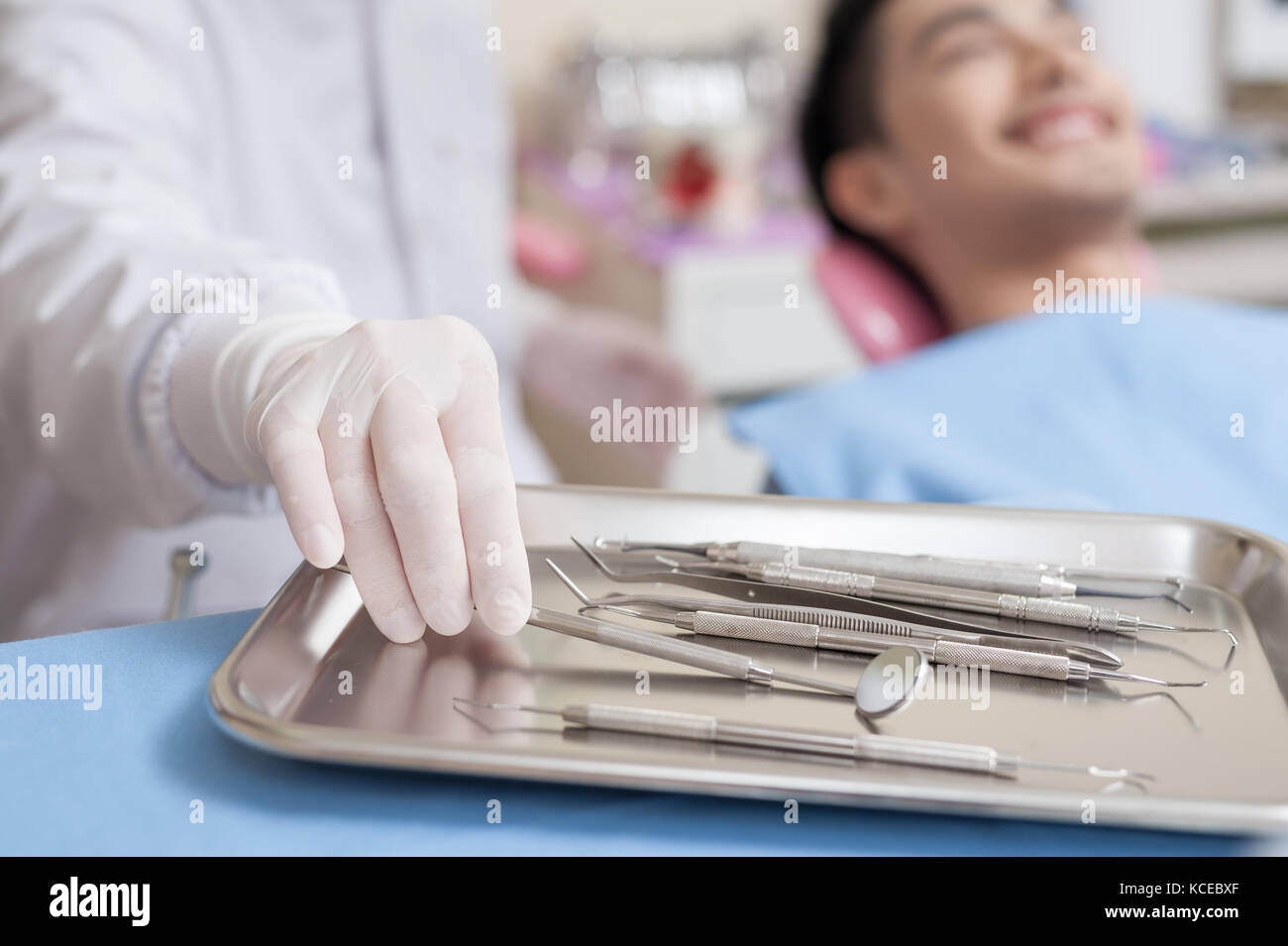 Dentist hand pick some instruments from metal tray in clinic. Dental
