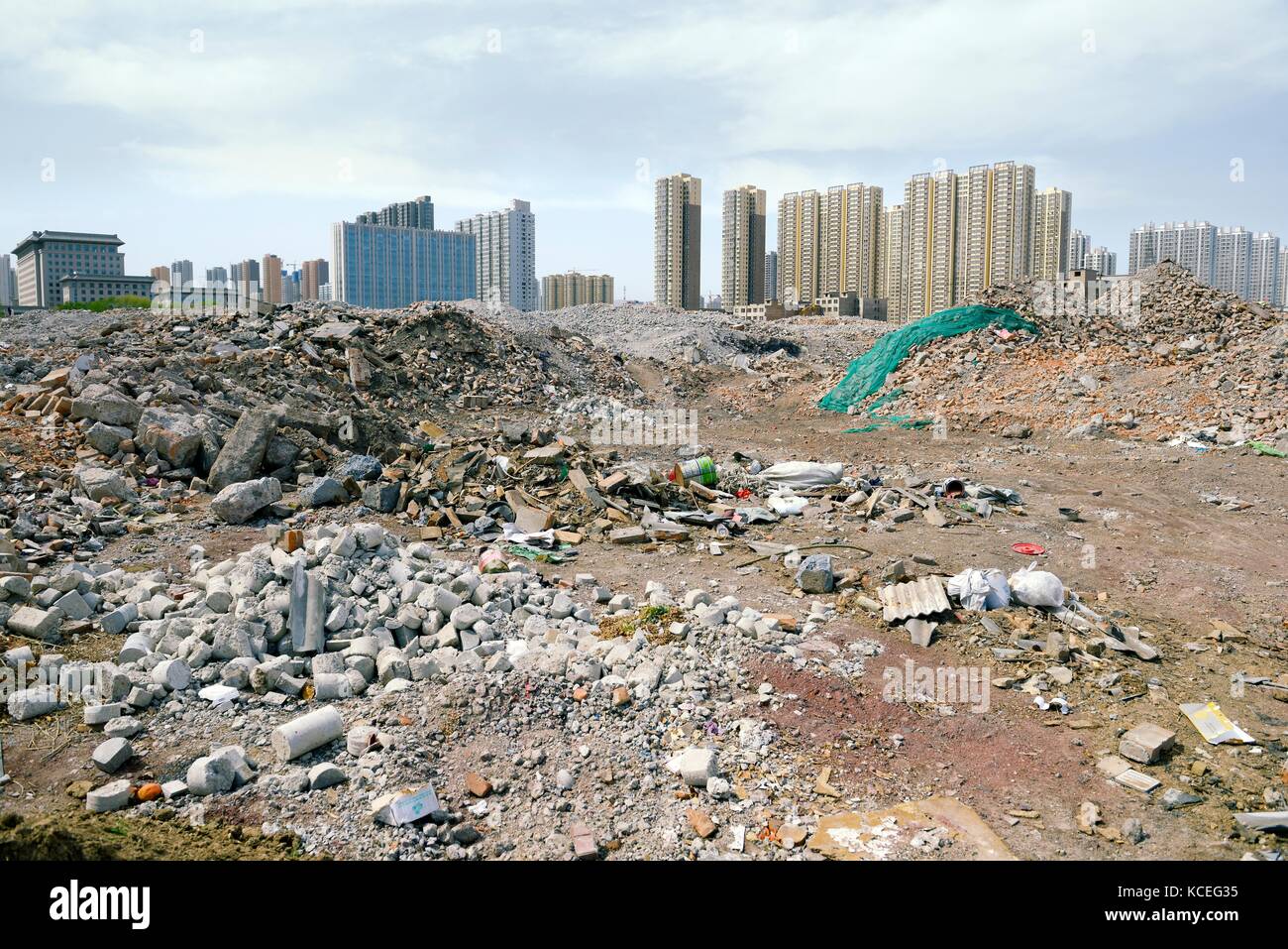 Inner city redevelopment Taiyuan city, Shanxi Province, China. Demolition debris from old hutong ghetto clearance. New high rise accommodation behind Stock Photo