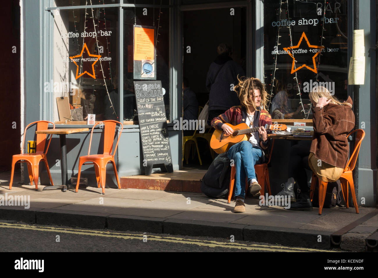 Young couple sit in sun at a table outside The Fossgate Social coffee