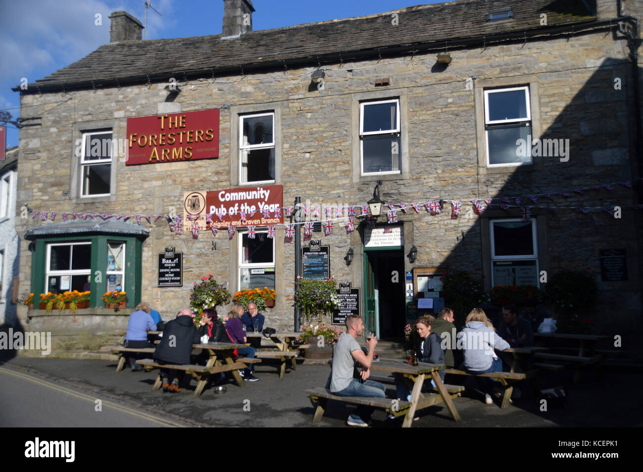 People Drinking in the Evening Sunshine at The Foresters Arms in the Village of Grassington in Wharfedale, Yorkshire Dales National Park, England, UK. Stock Photo