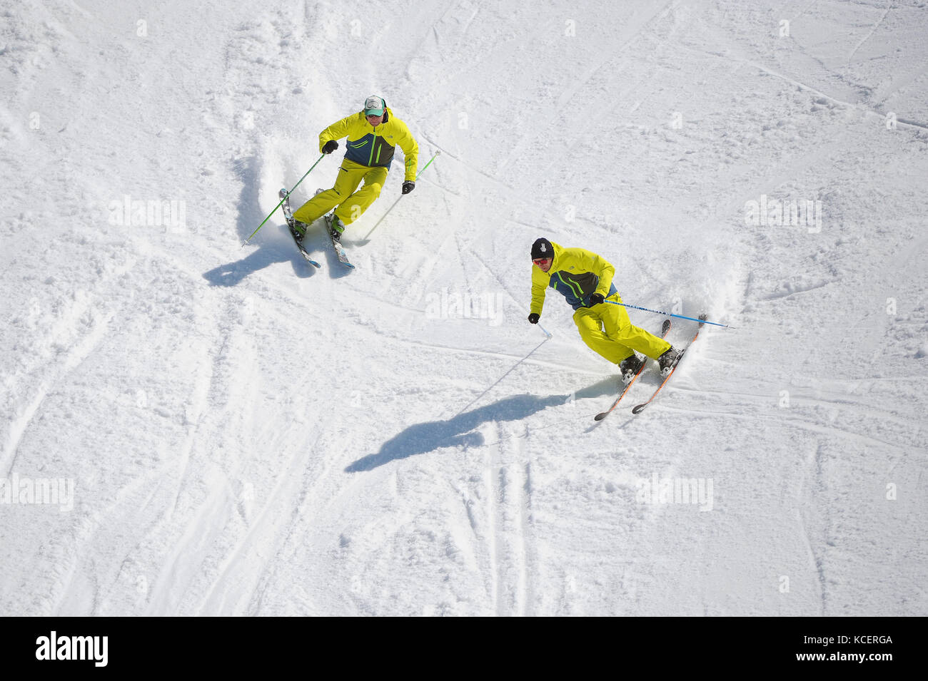 Two skiers carve turns photographed from above. Stock Photo
