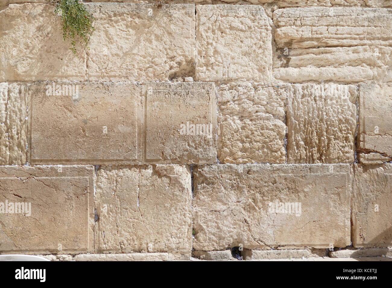 Slips of paper containing prayers in the cracks of the Western Wall (Ha-Kotel Ha-Ma'aravi) in Jerusalem. The Wall is the holiest of Jewish sites, sacred because it is a remnant of the Herodian retaining wall that once enclosed and supported the Second Temple. It has also been called the 'Wailing Wall' Stock Photo