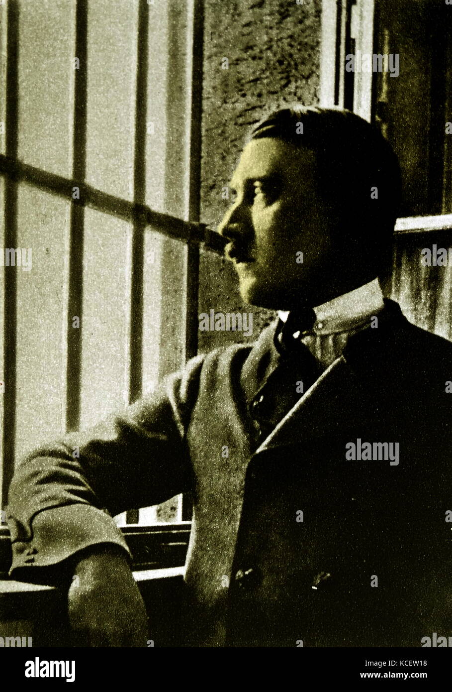 Adolf Hitler (1889-1945) looking out of the bars on the window to his prison cell at Landsberg Prison. In 1924 Adolf Hitler spent 264 days incarcerated in Landsberg after being convicted of treason following the Beer Hall Putsch in Munich the previous year. During his imprisonment, Hitler dictated and then wrote his book Mein Kampf with assistance from his deputy, Rudolf Hess. Stock Photo