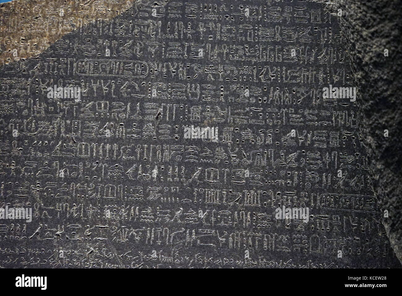 The Rosetta Stone is a rock stele, found in 1799, inscribed with a decree issued at Memphis, Egypt, in 196 BC on behalf of King Ptolemy V. The decree appears in three scripts: the upper text shown here, is Ancient Egyptian hieroglyphs Stock Photo