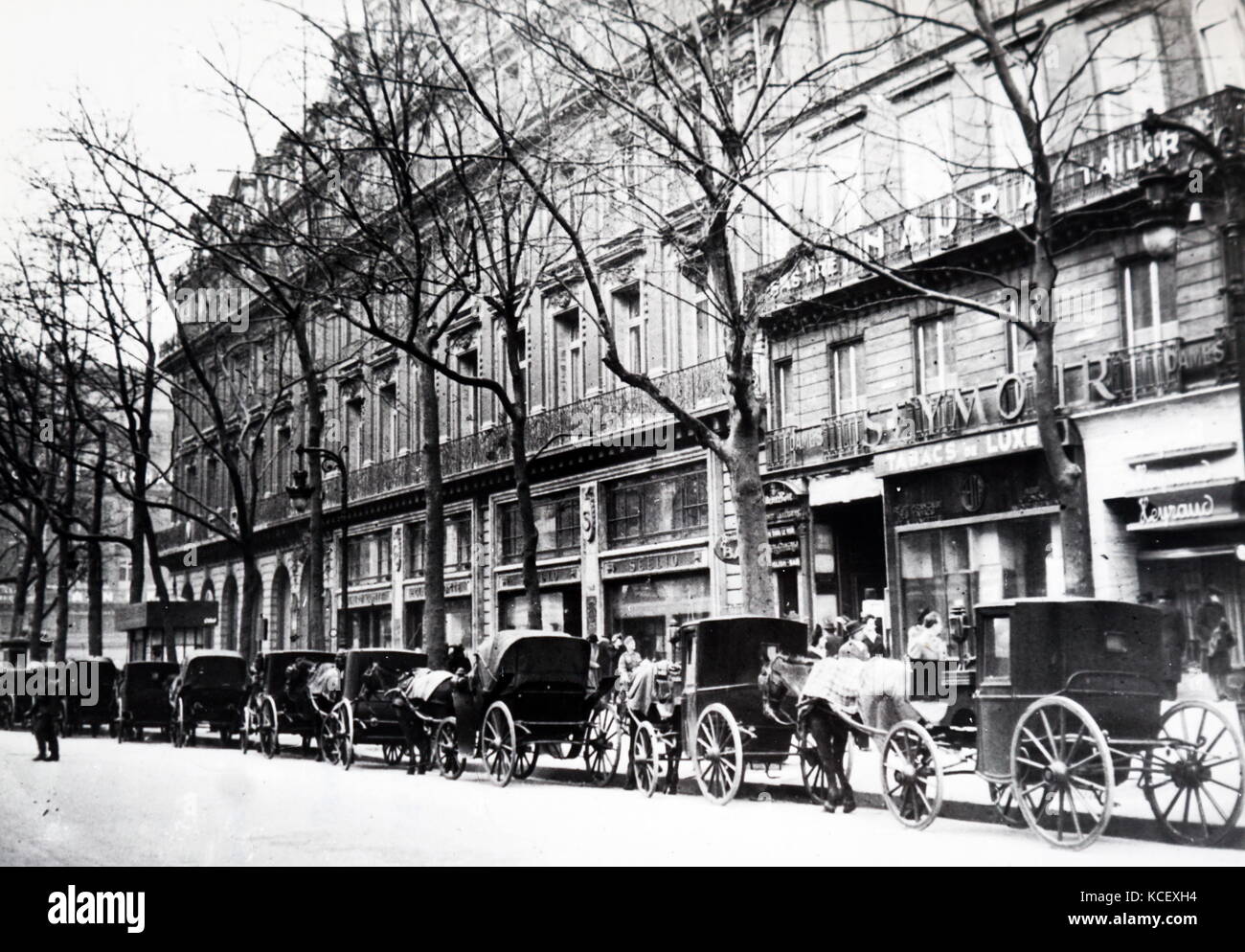 Photograph of horse drawn taxi cabs line a street in Paris, during the German occupation of France. Dated 20th Century Stock Photo