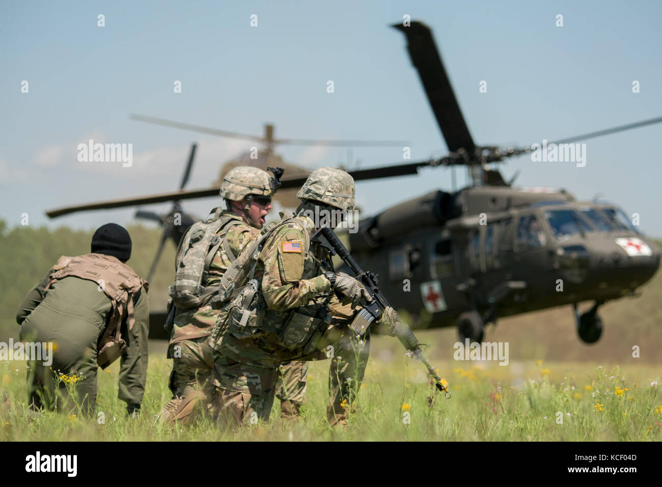 Soldiers and a pilot await the arrival of a UH-60 Black Hawk rescue during the combined arms demonstration hosted by the South Carolina Guard Air &amp; Ground Expo at McEntire Joint National Guard Base, South Carolina, May 6, 2017. This expo is to showcase the abilities of South Carolina National Guard Airmen and Soldiers while saying thank you for the support of fellow South Carolinians and the surrounding community. (U.S. Army National Guard photo by Sgt. Brian Calhoun) Stock Photo
