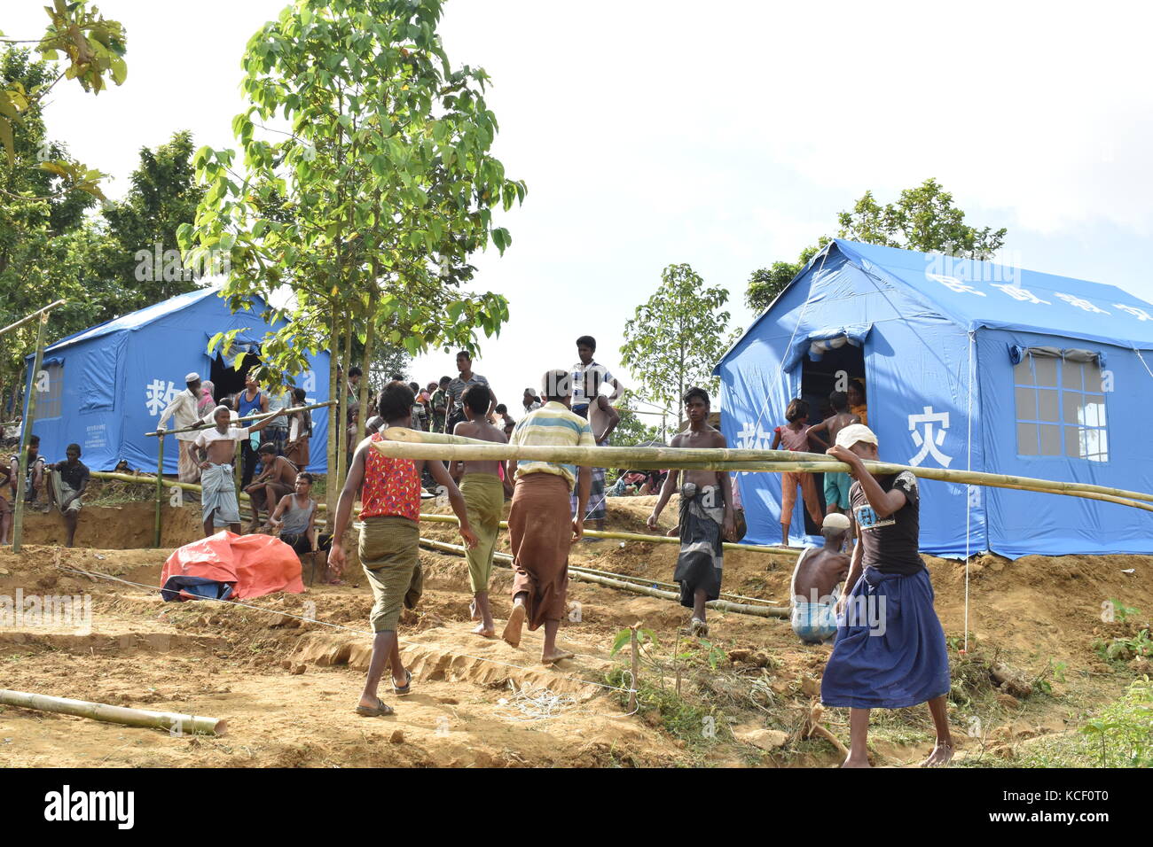 (171004) -- DHAKA, Oct. 4, 2017 (Xinhua) -- People walk near Chinese relief tents at a camp in Cox's Bazaar district, Bangladesh, on Oct. 3, 2017. China has sent relief supplies for Rohingya refugees in Bangladesh recently. (Xinhua/Jibon Ahsan) (zcc) Stock Photo
