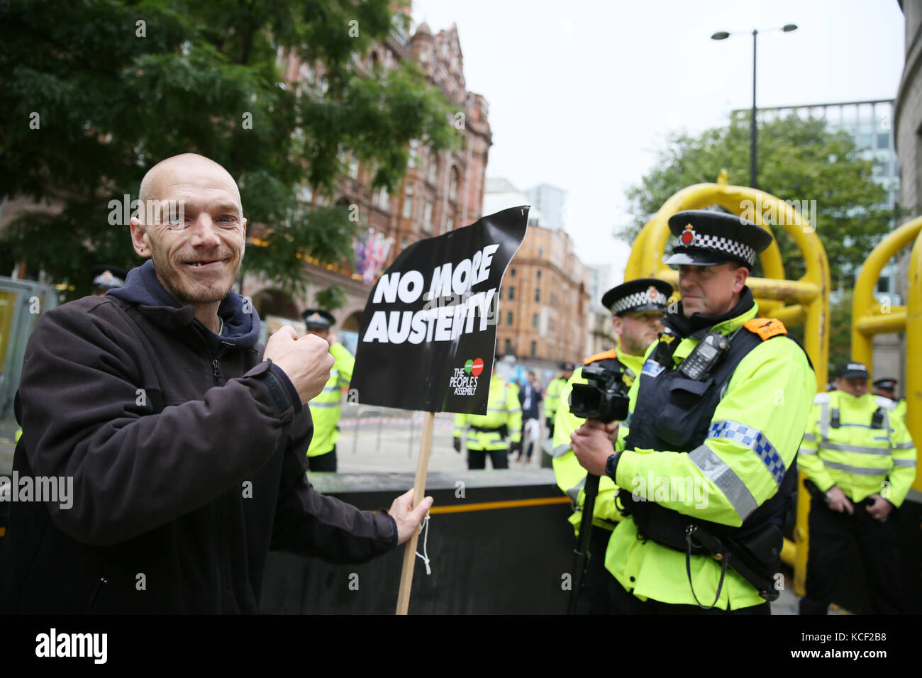 Manchester, UK. 4th Oct, 2017. A protester using a placard which reads 'No More Austerity' to block filming by Police evidence gatherers outside the Conservative Party Conference, Manchester,4th October, 2017 Credit: Barbara Cook/Alamy Live News Stock Photo