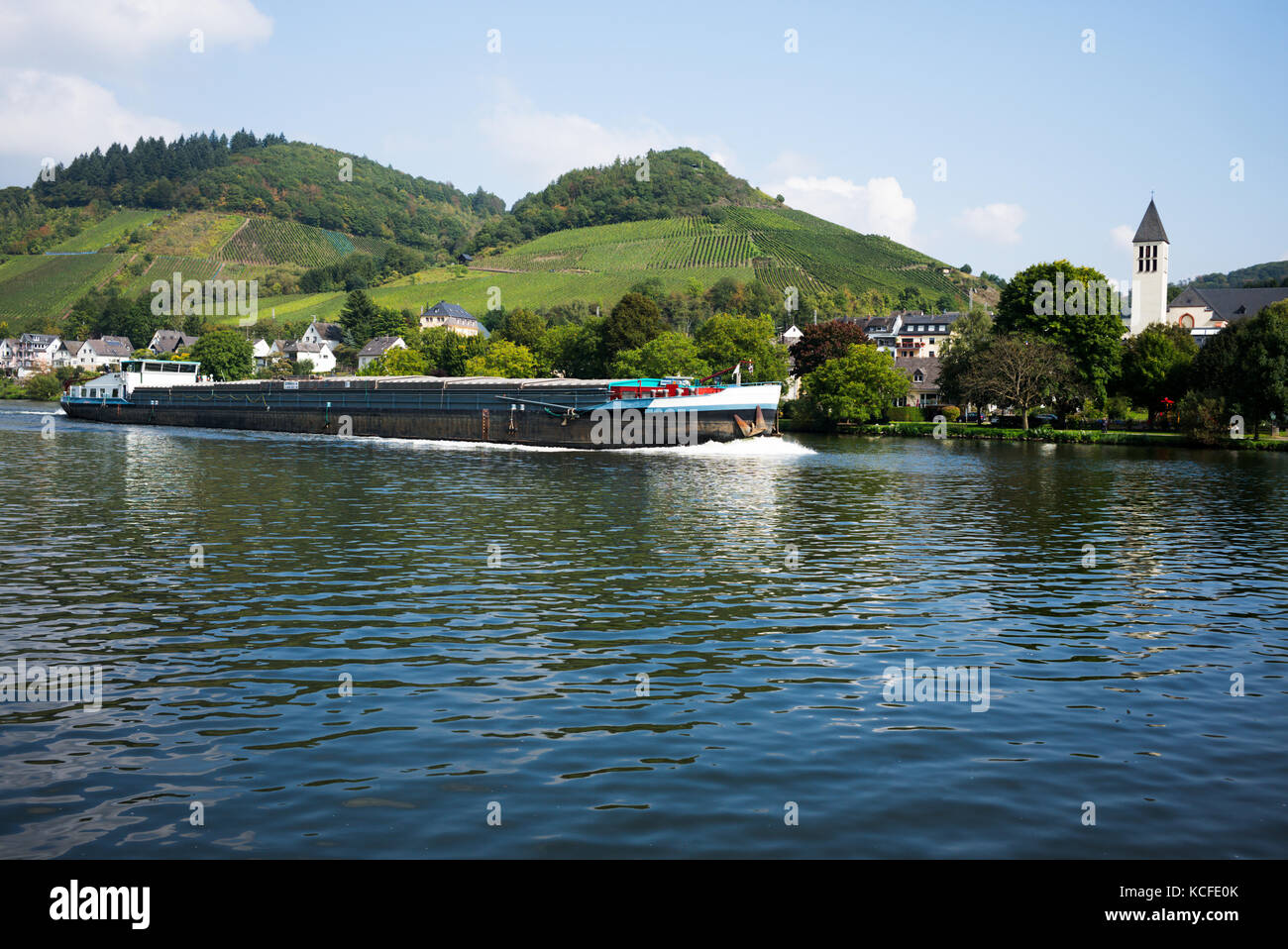 A barge passes the Village of Bullay on the river Moselle, Germany Stock Photo