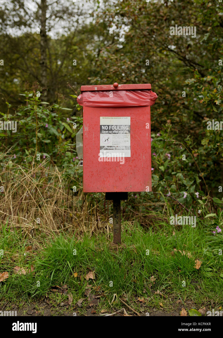Red dog waste bin in burrs country park bury lancashire uk Stock Photo