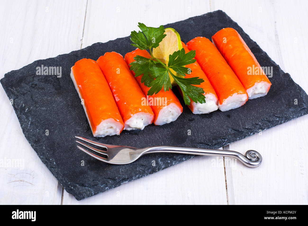 Surimicrab sticks on black plate Stock Photo Alamy