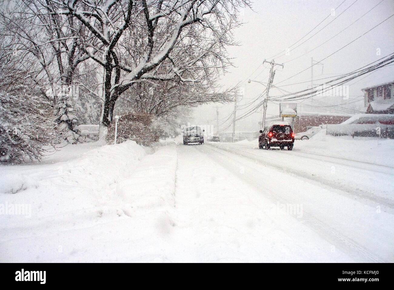 Snow plows work hard to clear deep snow on roads following a blizzard. Stock Photo