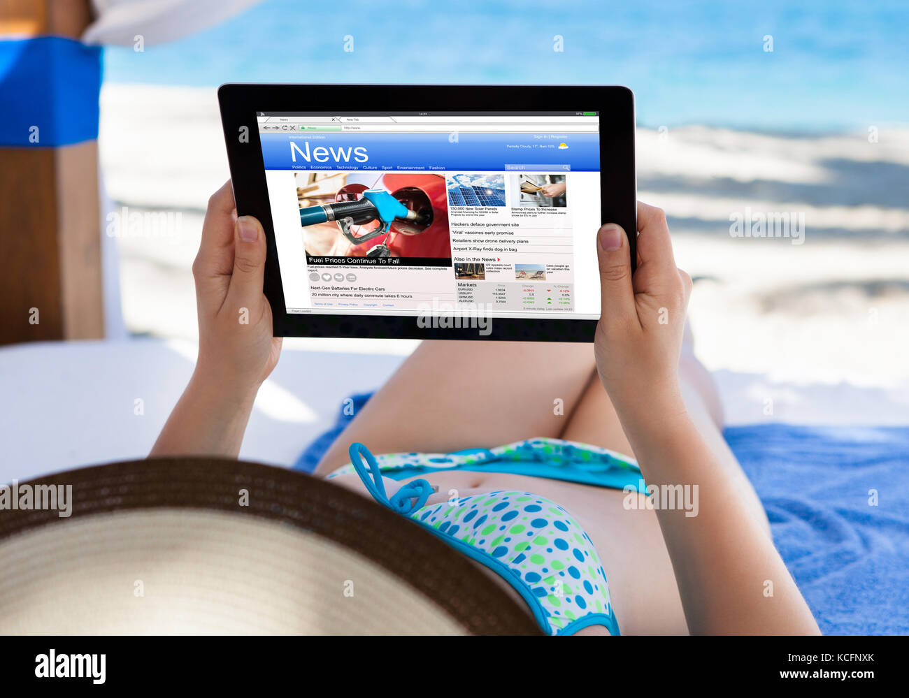 Close-up Of A Woman Reading News On Digital Tablet At Beach Stock Photo