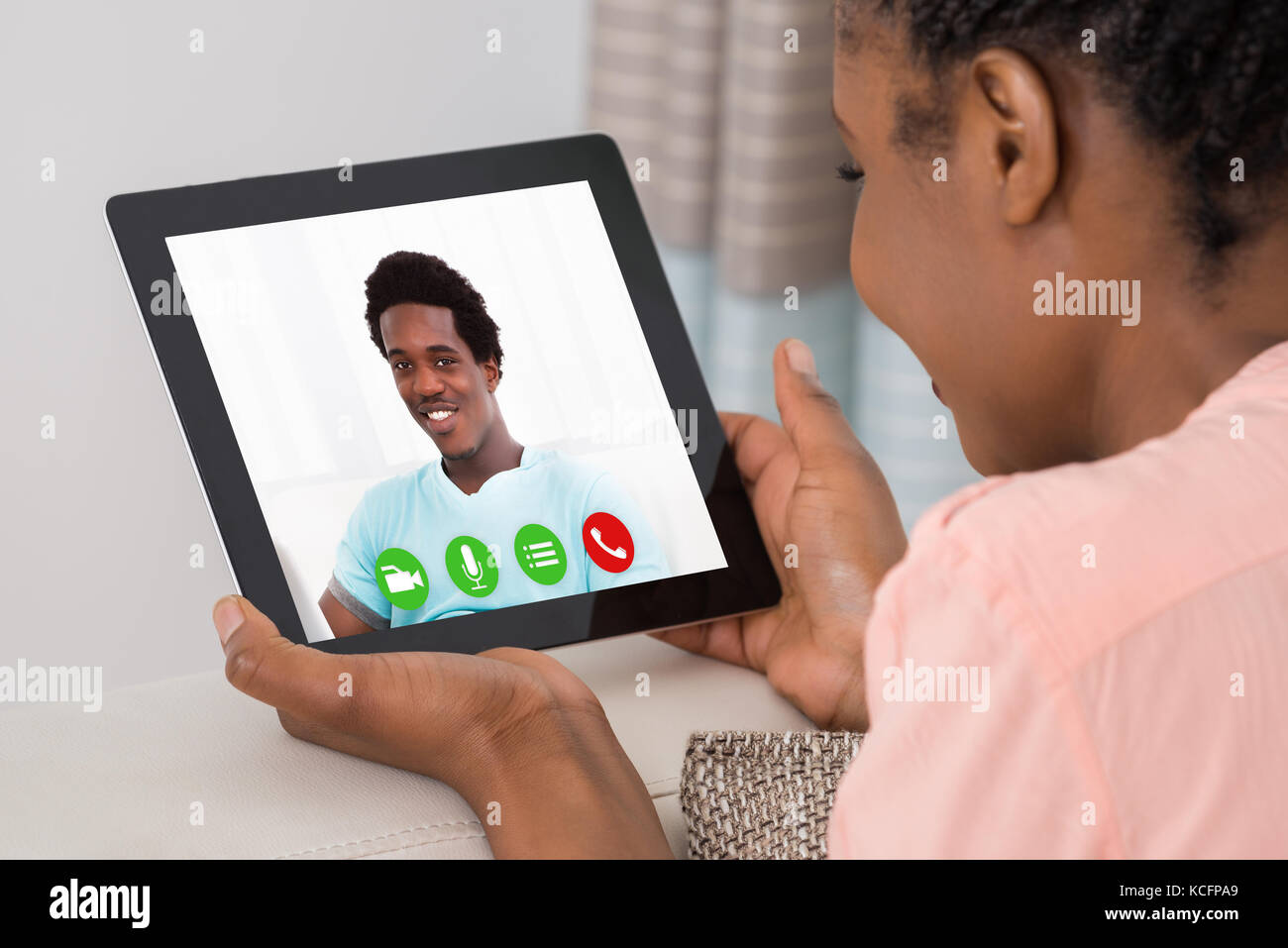 Close-up Of A Young Woman Video Conferencing With Man On Digital Tablet Stock Photo