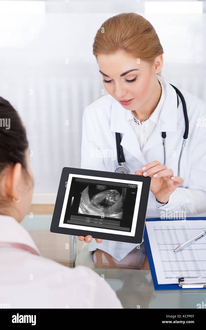 Female Doctor With Digital Tablet Showing Ultrasound Scan Of Baby To Patient Stock Photo