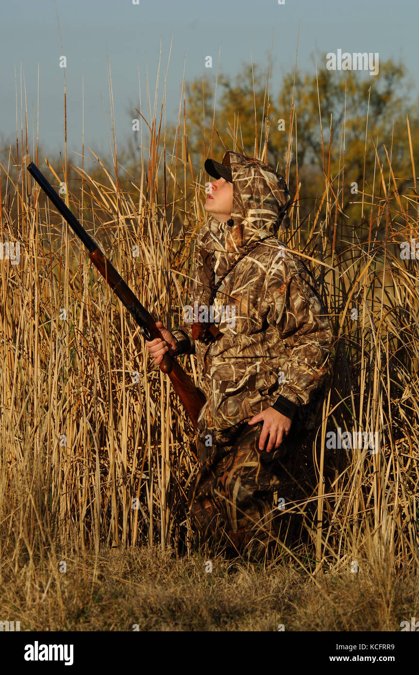 A duck hunter in camouflage calls ducks from a marsh in South Texas