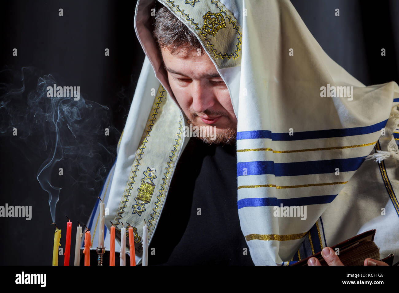 man lighting candles in menorah Jewish man in prayer on table served