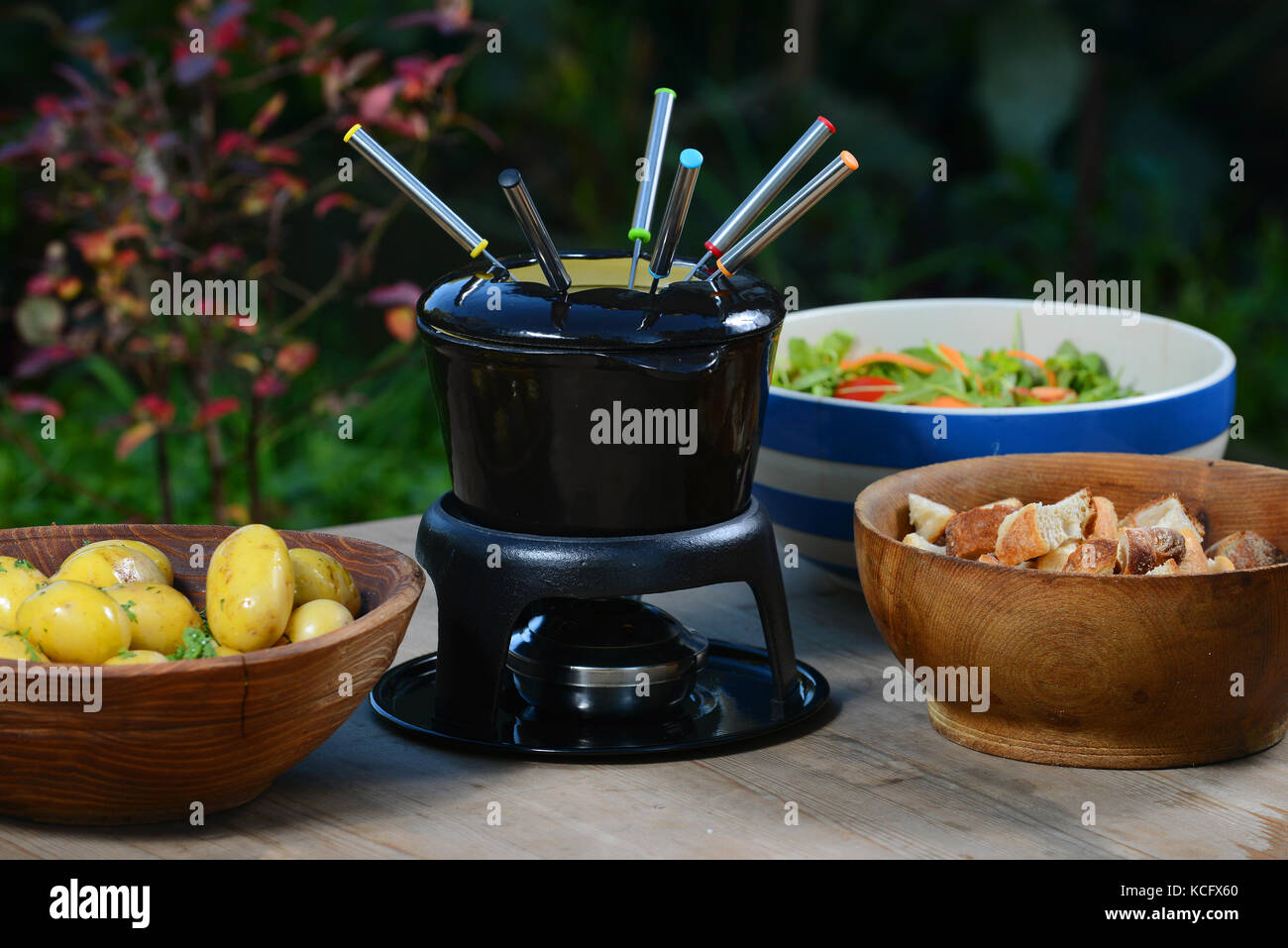 A cheese fondue with boiled potatoes, bread and salad Stock Photo Alamy