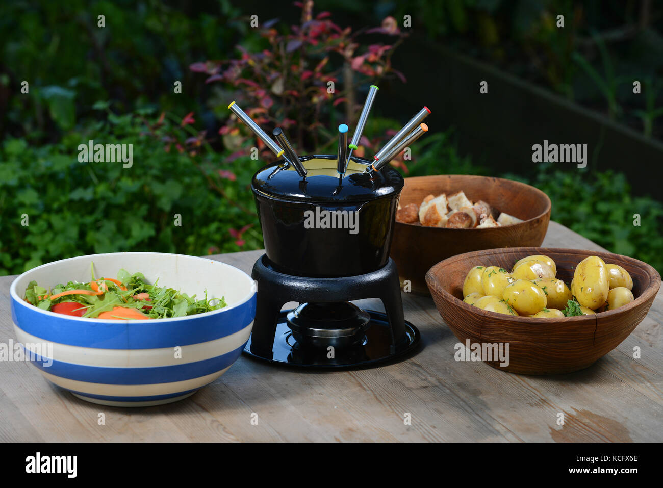 A cheese fondue with boiled potatoes, bread and salad Stock Photo Alamy